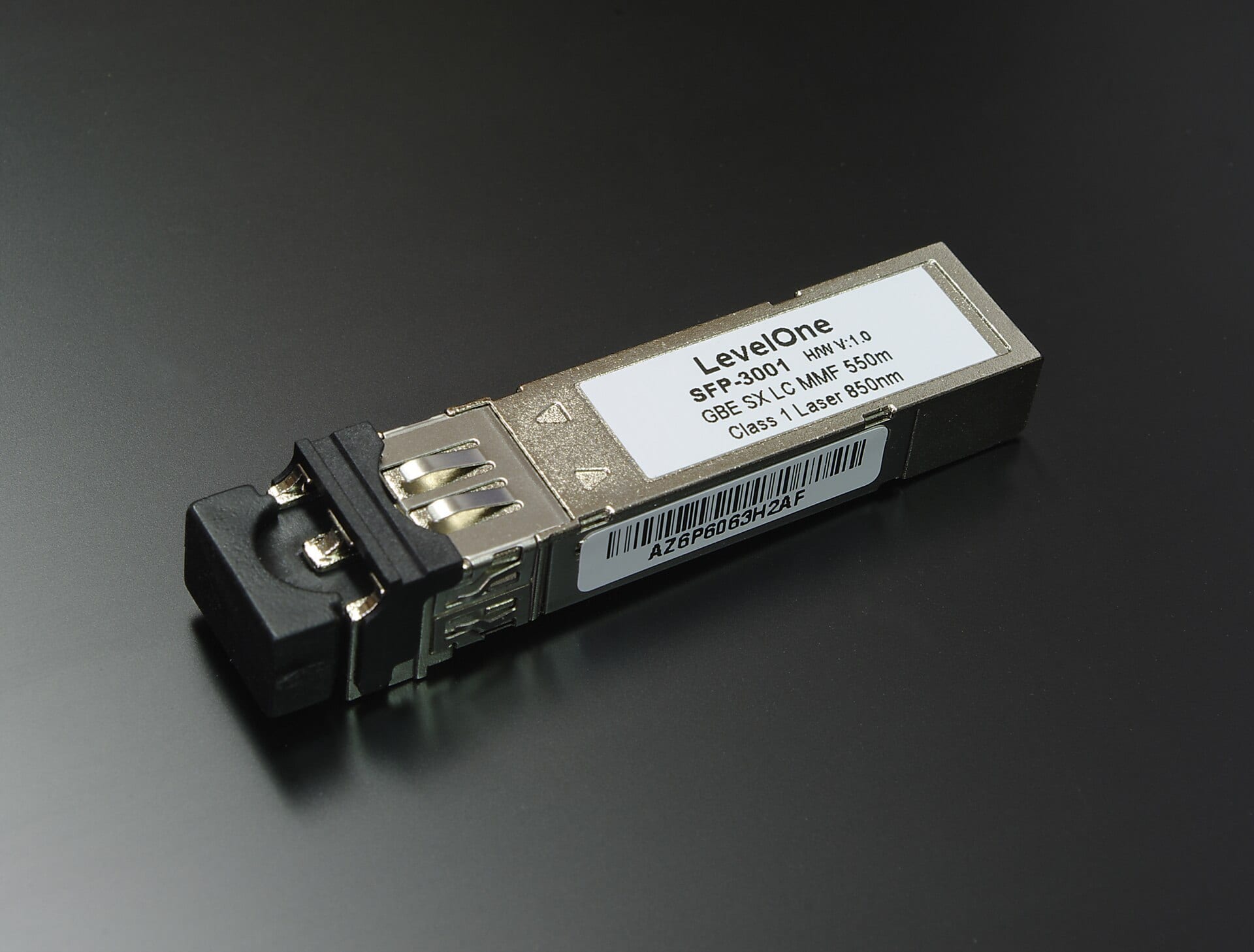A LevelOne SFP-3001 optical transceiver module on a dark surface