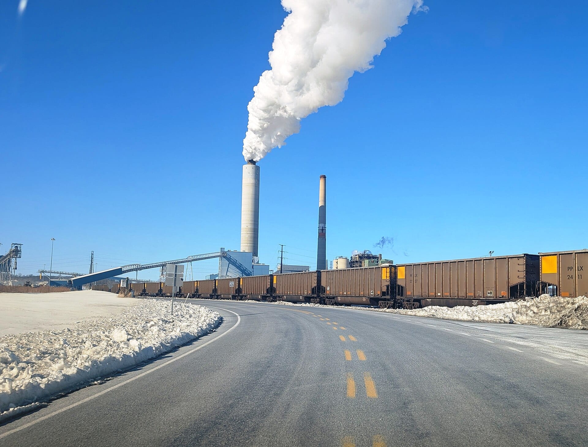 Brunner Island Steam Electric Station in York County, Pennsylvania, with a coal train in the foreground and steam rising from its stack, February 2026.