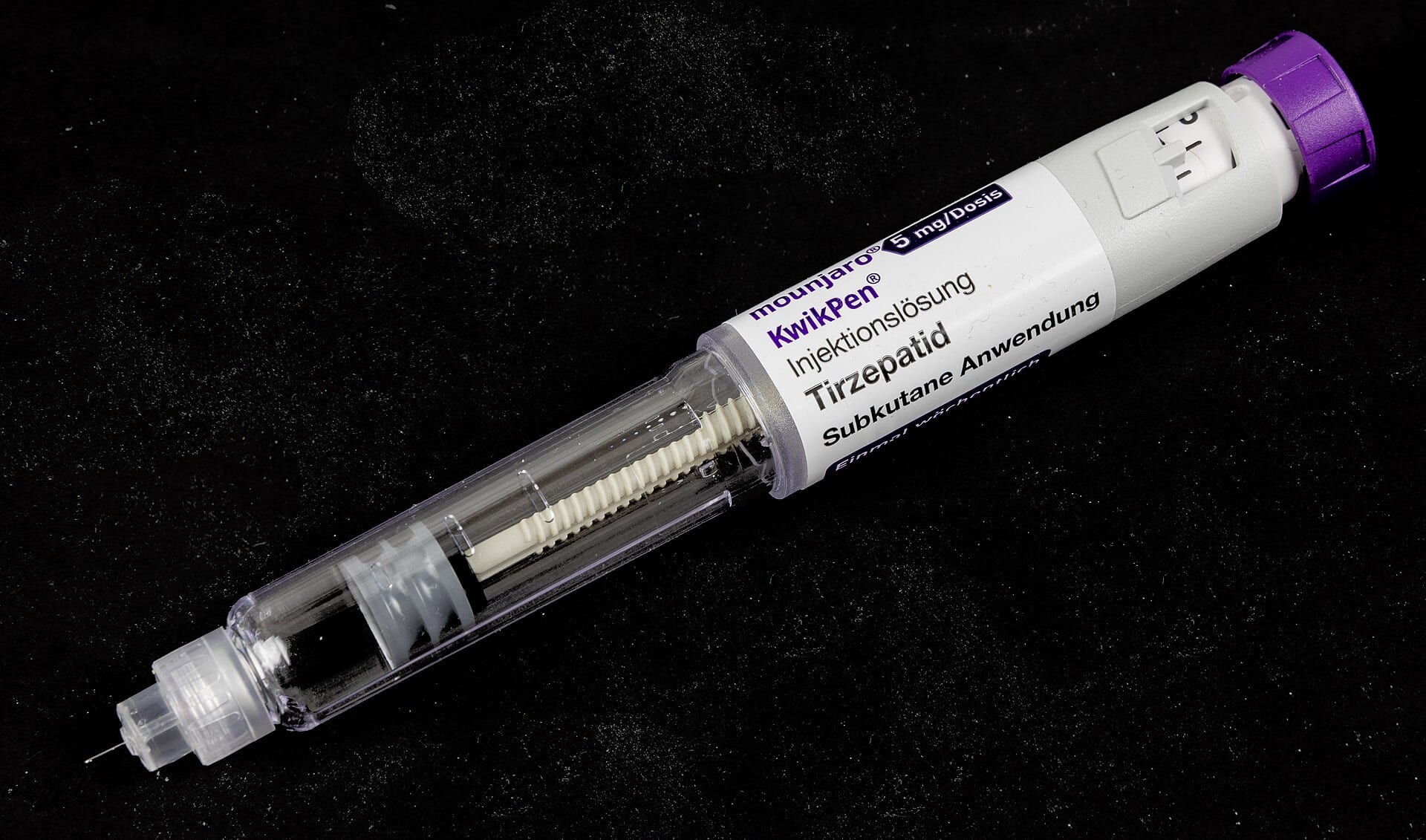 A Mounjaro KwikPen, Lilly's weekly tirzepatide injection pen, on a black background