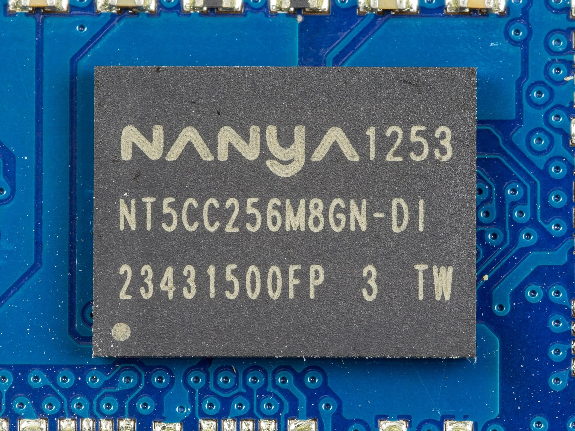 Close-up of a Nanya Technology DRAM chip, part number NT5CC256M8GN-DI, soldered onto a blue Kingston memory module.