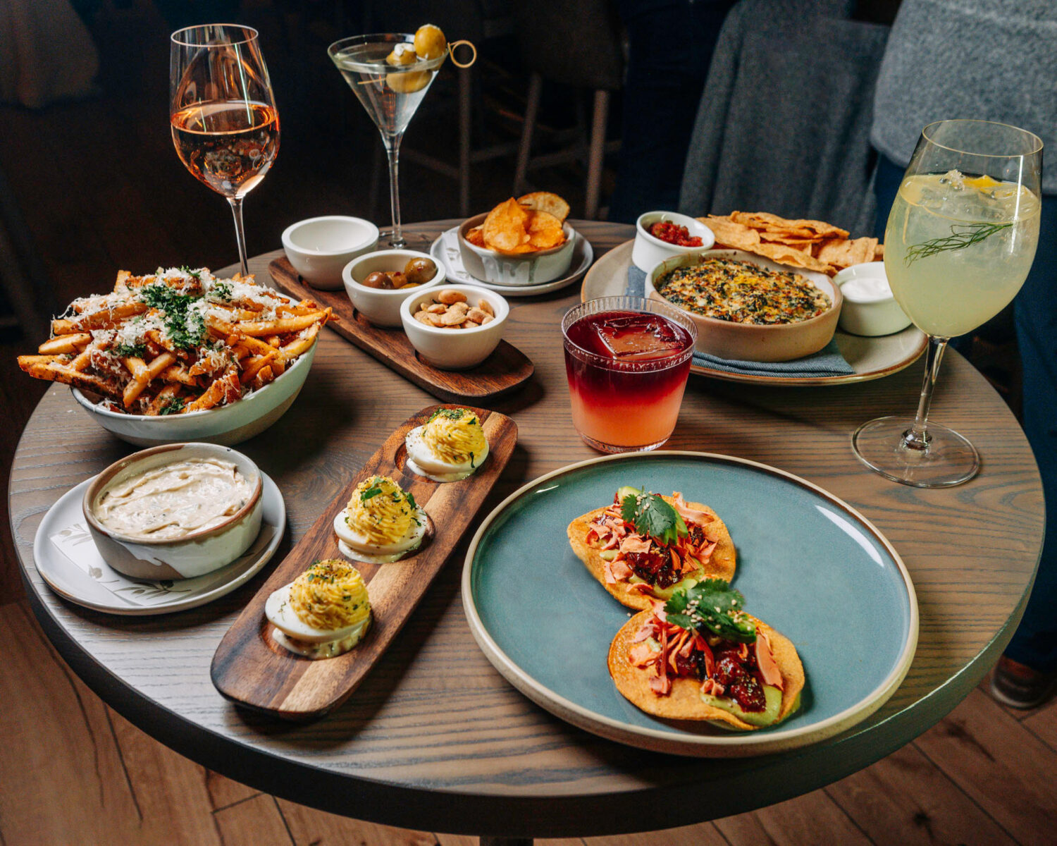 Spread of dishes and drinks all available during The Oakville's Happy Hour