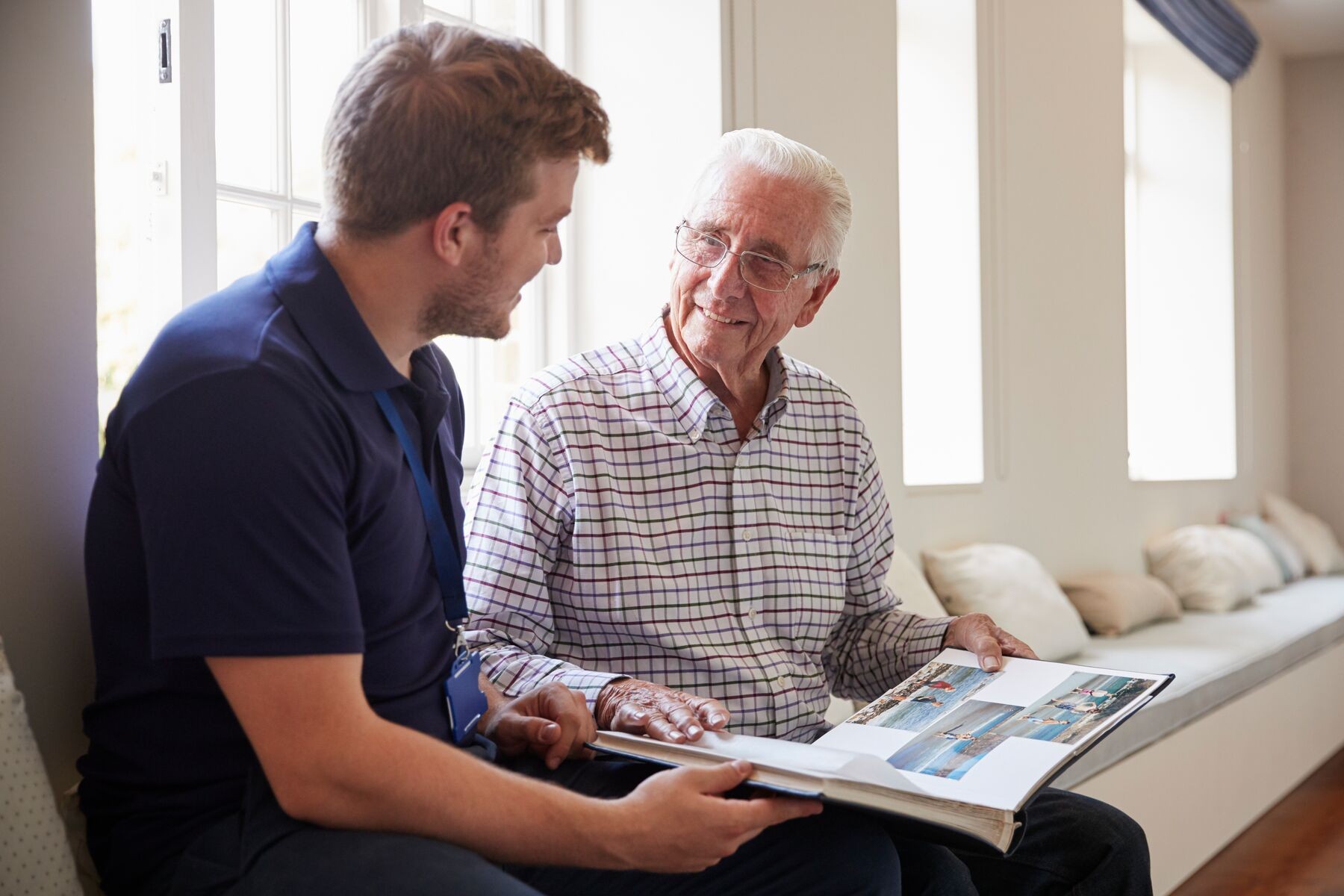 man with male nurse looking at photo album