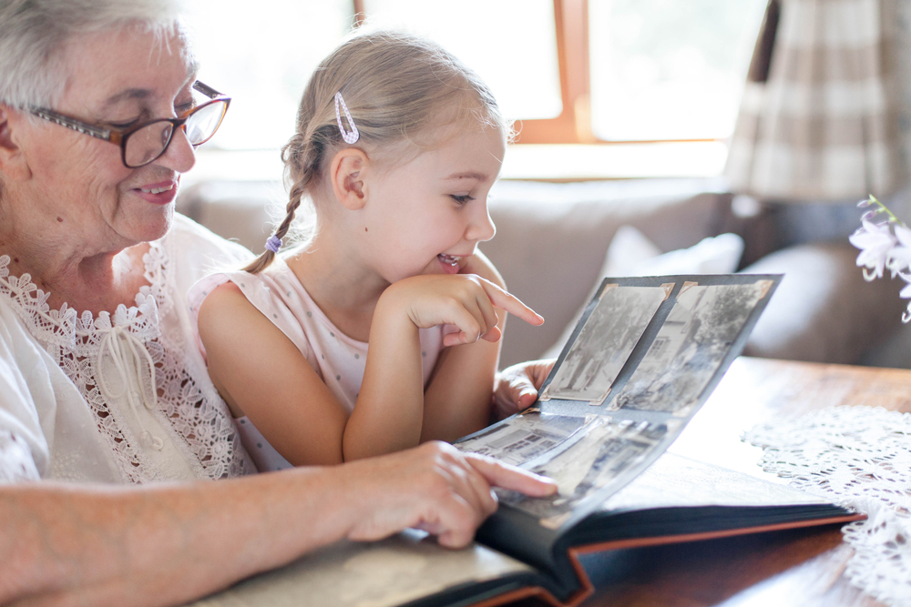 A granddaughter and grandmother look at a photo album together