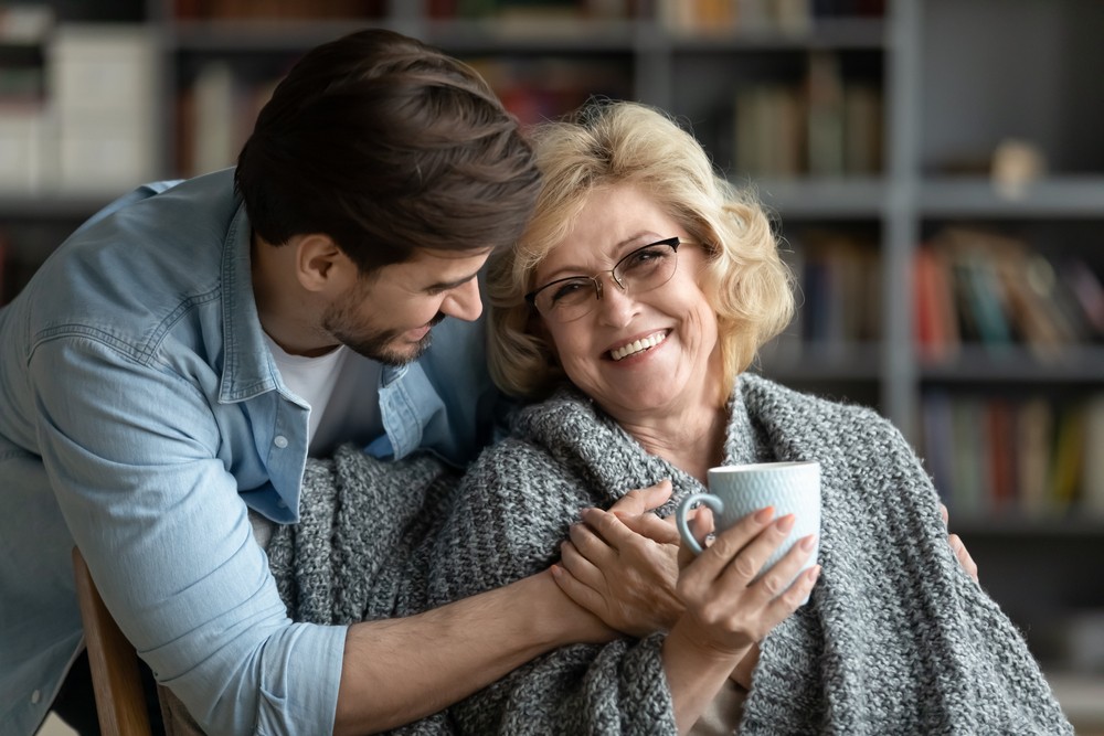 Senior woman getting tea from adult son