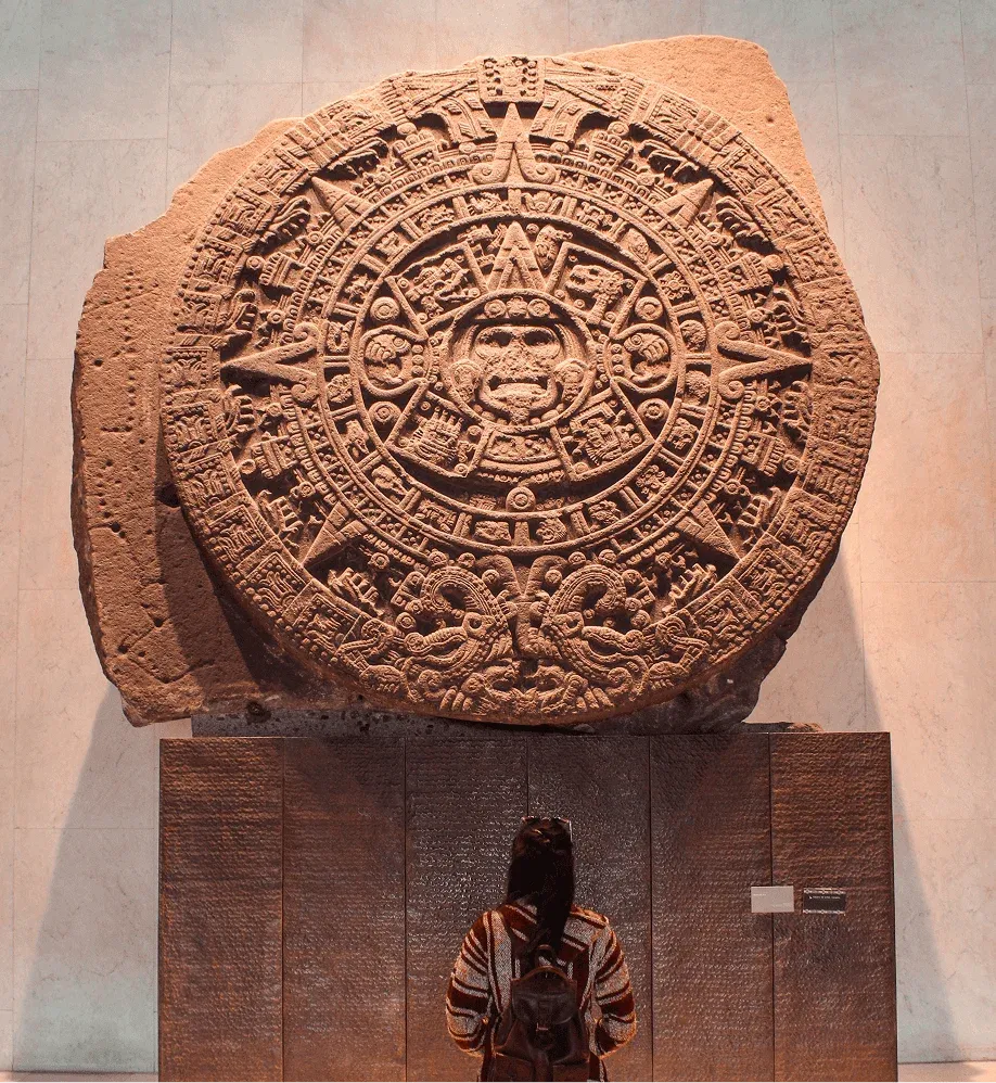 Visitor observing the Sun Stone at the Museo Nacional de Antropología in Mexico City