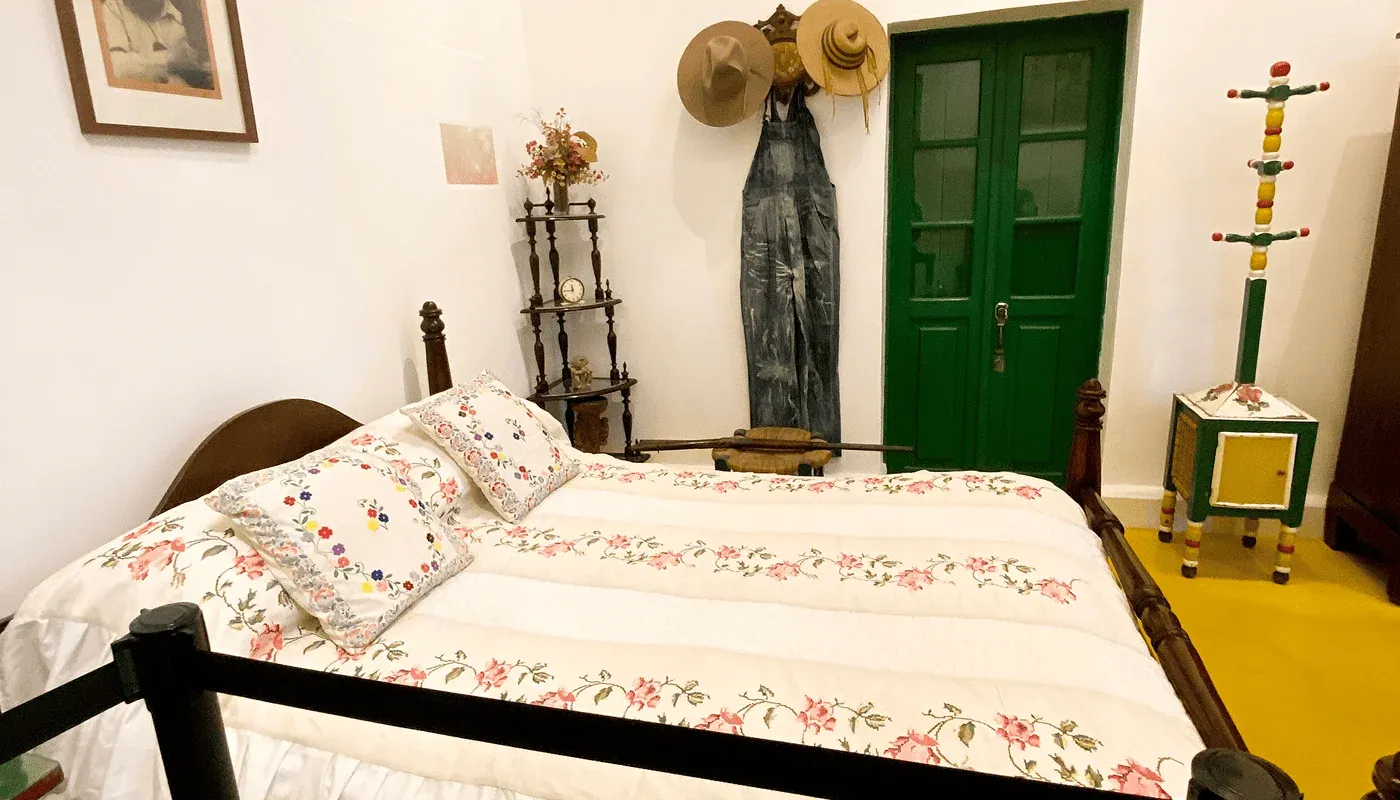 Interior room of the Frida Kahlo Museum with a wooden bed