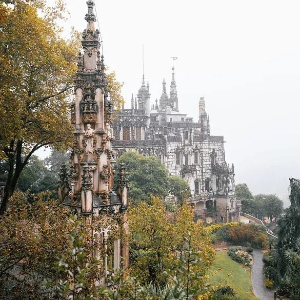 Panoramablick auf den Palast von Quinta da Regaleira zwischen Gärten und Vegetation in Sintra, Portugal.