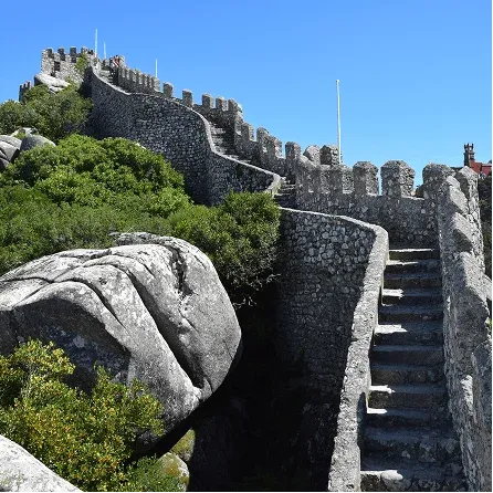 Stone walls and stairways of the Moorish Castle in Sintra with panoramic views over the surrounding hills.
