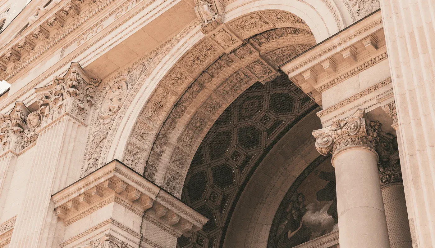 Detail van de ingang van de Sint-Stefanusbasiliek in Boedapest met neoklassieke zuilen en reliëfs.