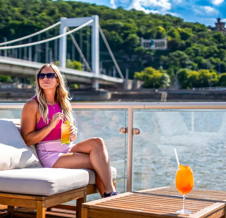 Pasajera disfrutando de un crucero por el Danubio en la cubierta panorámica de un barco en Budapest.