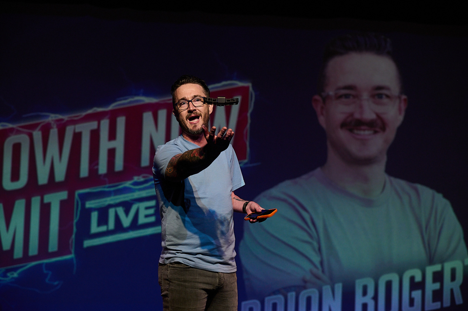 Brian Bogert speaking on stage at the Growth Now Summit with AI drone demonstration