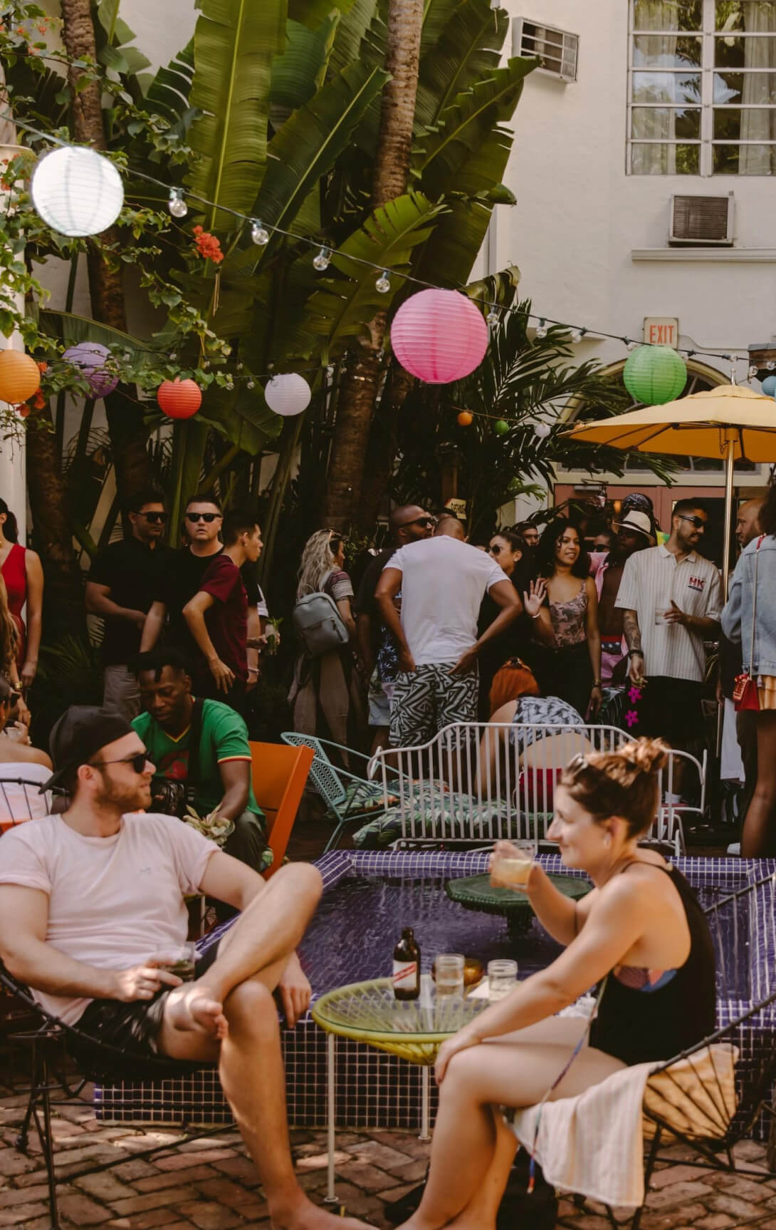 Broken Shaker - Miami - Multi-colored string-lit Patio filled with people drinking and conversing