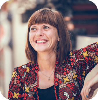 A photograph of a smiling person leaning against a wall.