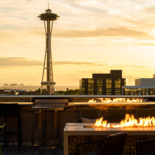 Altitude Sky Lounge. - Seattle Space needle with skyline and sunset with a foreground of an outdoor fireplace feature