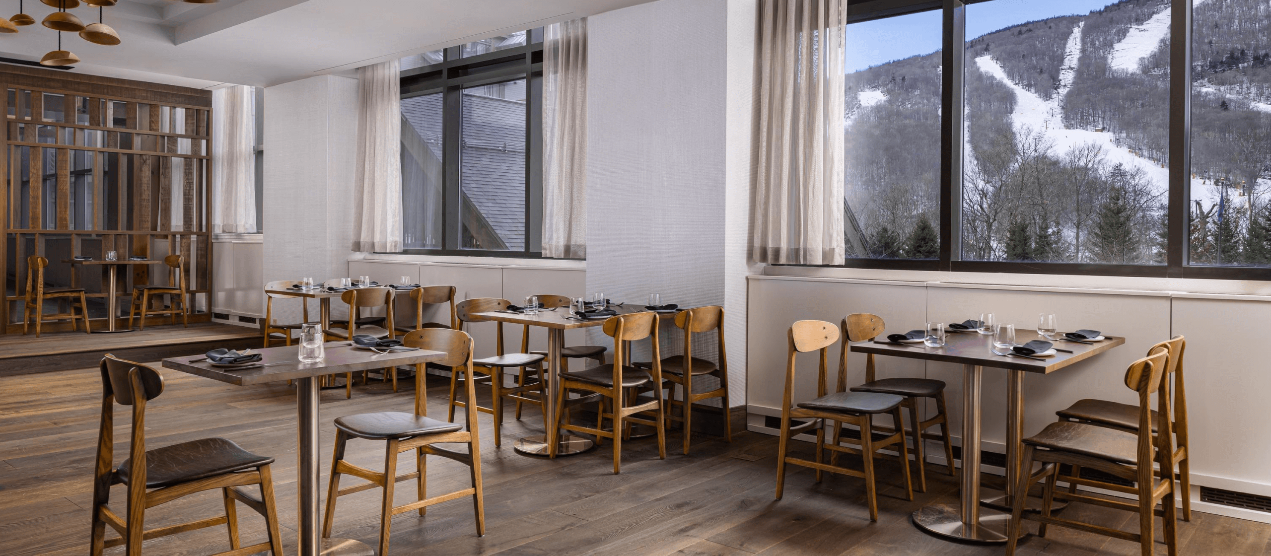 A restaurant’s dining room with views of mountains in the background.