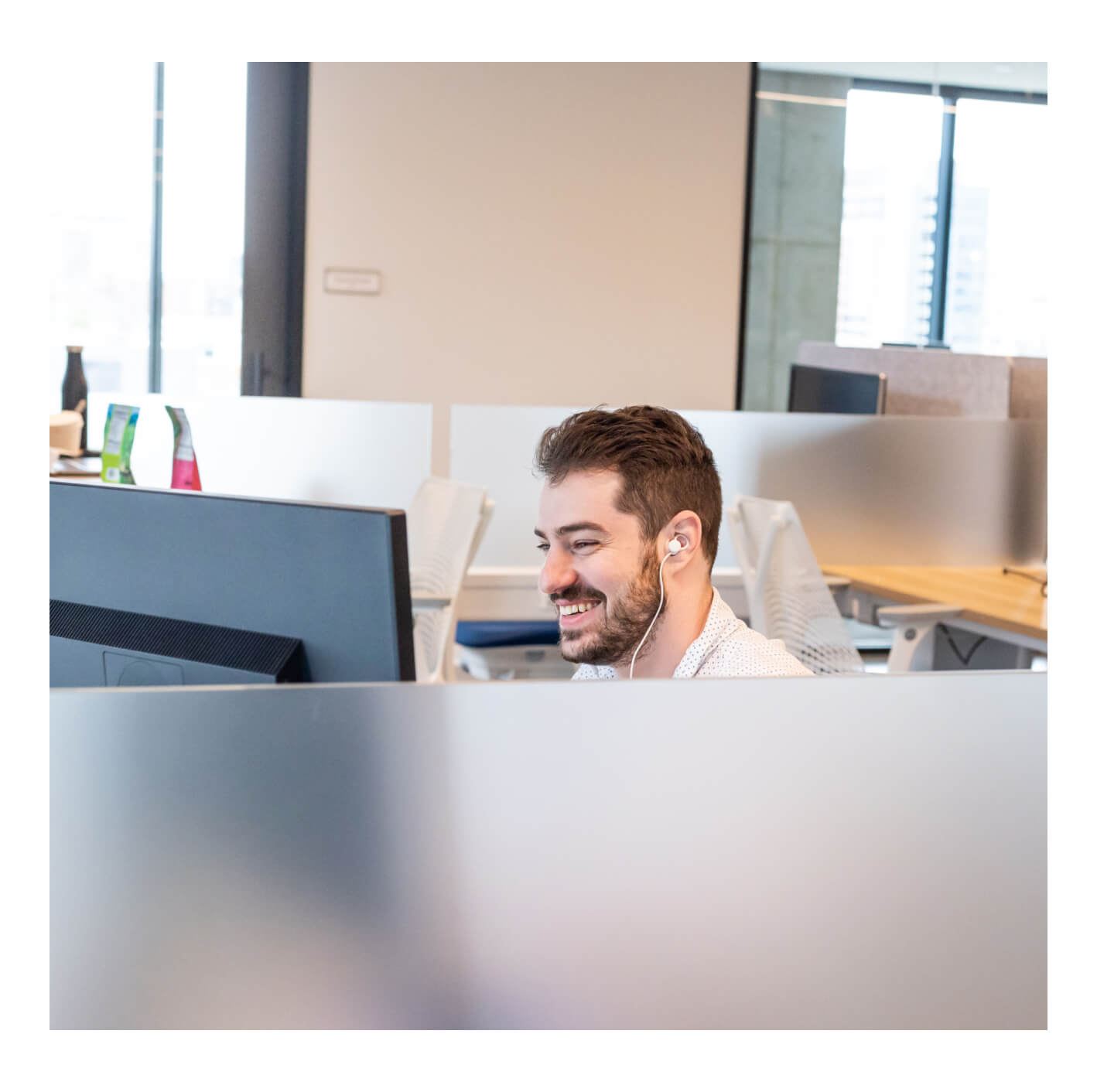 An image of a smiling Tock employee wearing headphones.