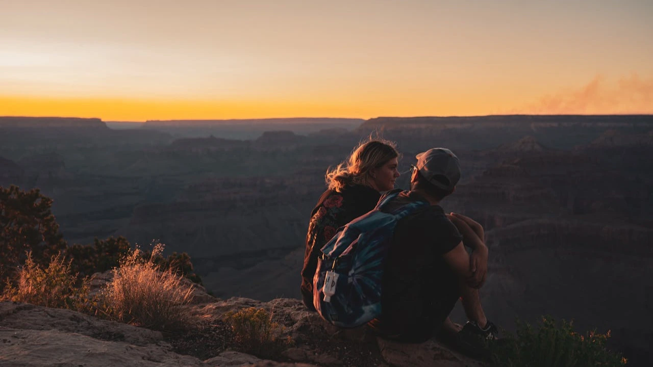 A hiking couple having a romantic time during sunset A hiking couple having a romantic time during sunset