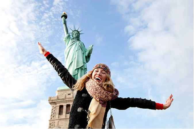 Woman taking a picture with the Statue of Liberty