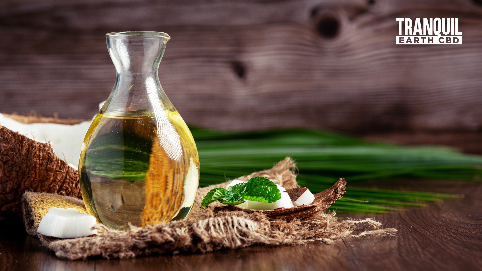 a carafe of coconut oil with pieces of coconuts behind it