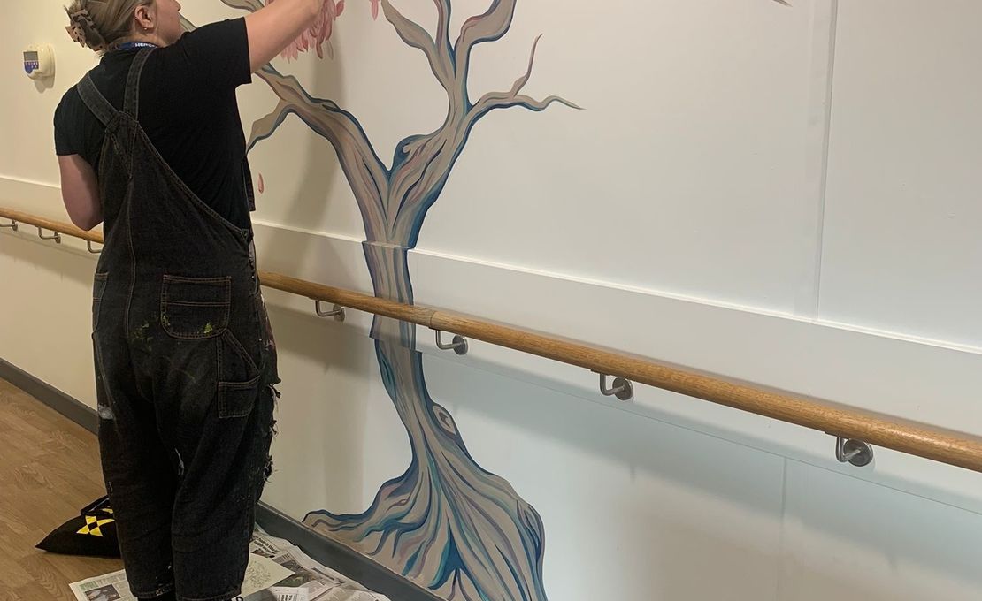 Amy Edisbury Williams at work on a hospital mural