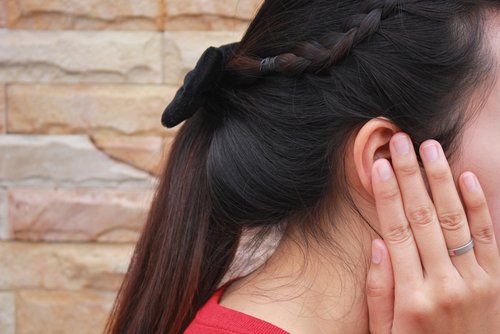 woman holding ear