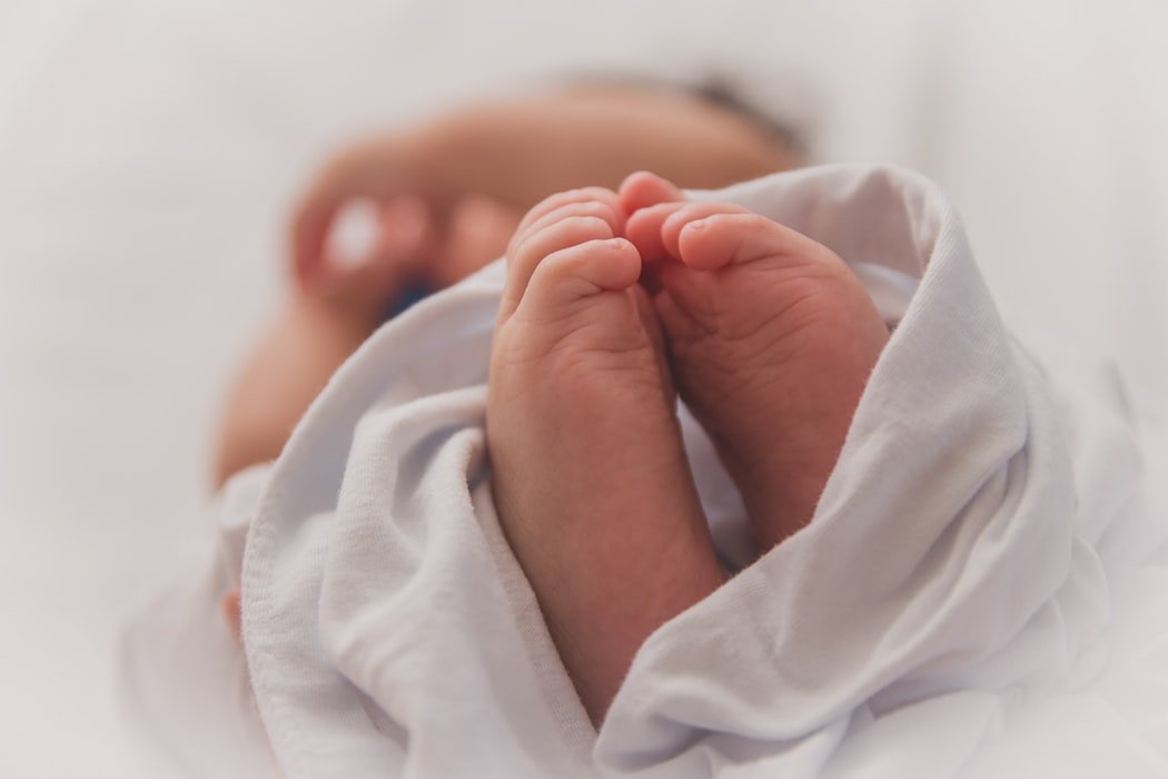 feet of a young baby wrapped in a blanket