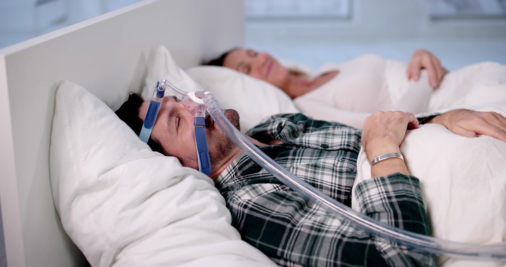 Tired Man Finds Relief In Sleep Apnea CPAP Mask Machine