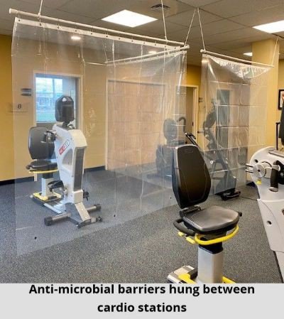 Anti-microbial barriers hung between cardio stations