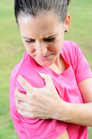 Woman holding her shoulder