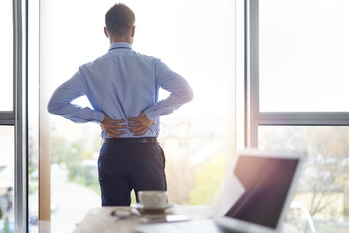 man rubbing lower back