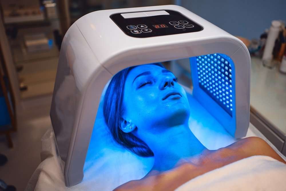 LED red light is treating the facial skin of a young woman. High quality 4k footage
