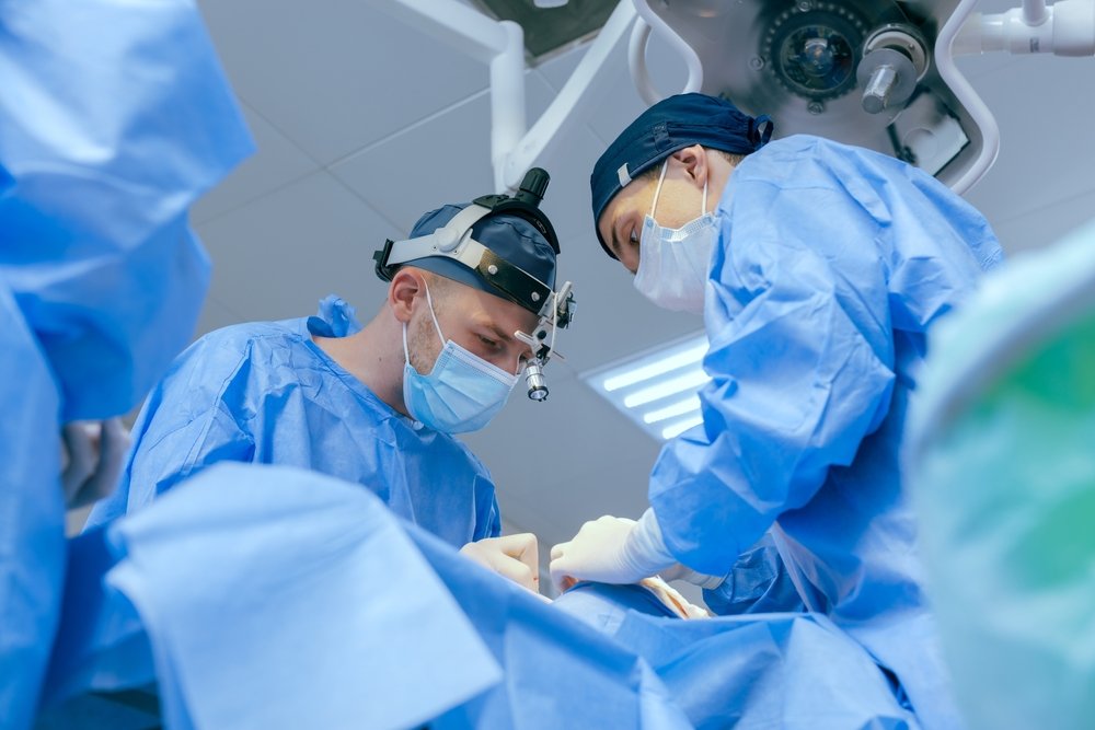 A podiatrist examining a bunion at the base of a patient