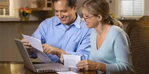 A couple using their laptop to pay bills