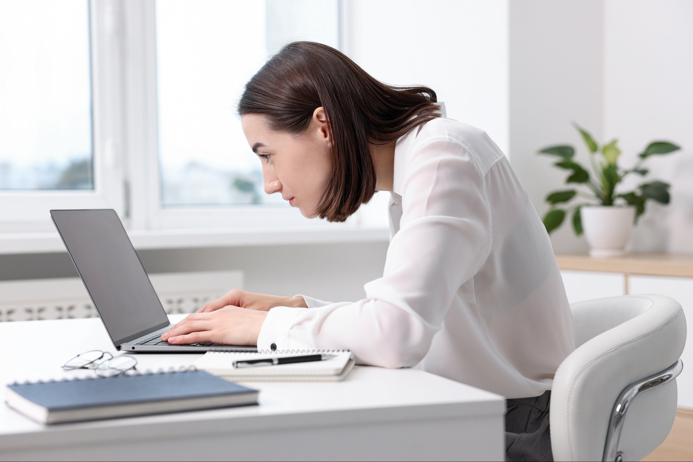 Woman with poor posture working in office