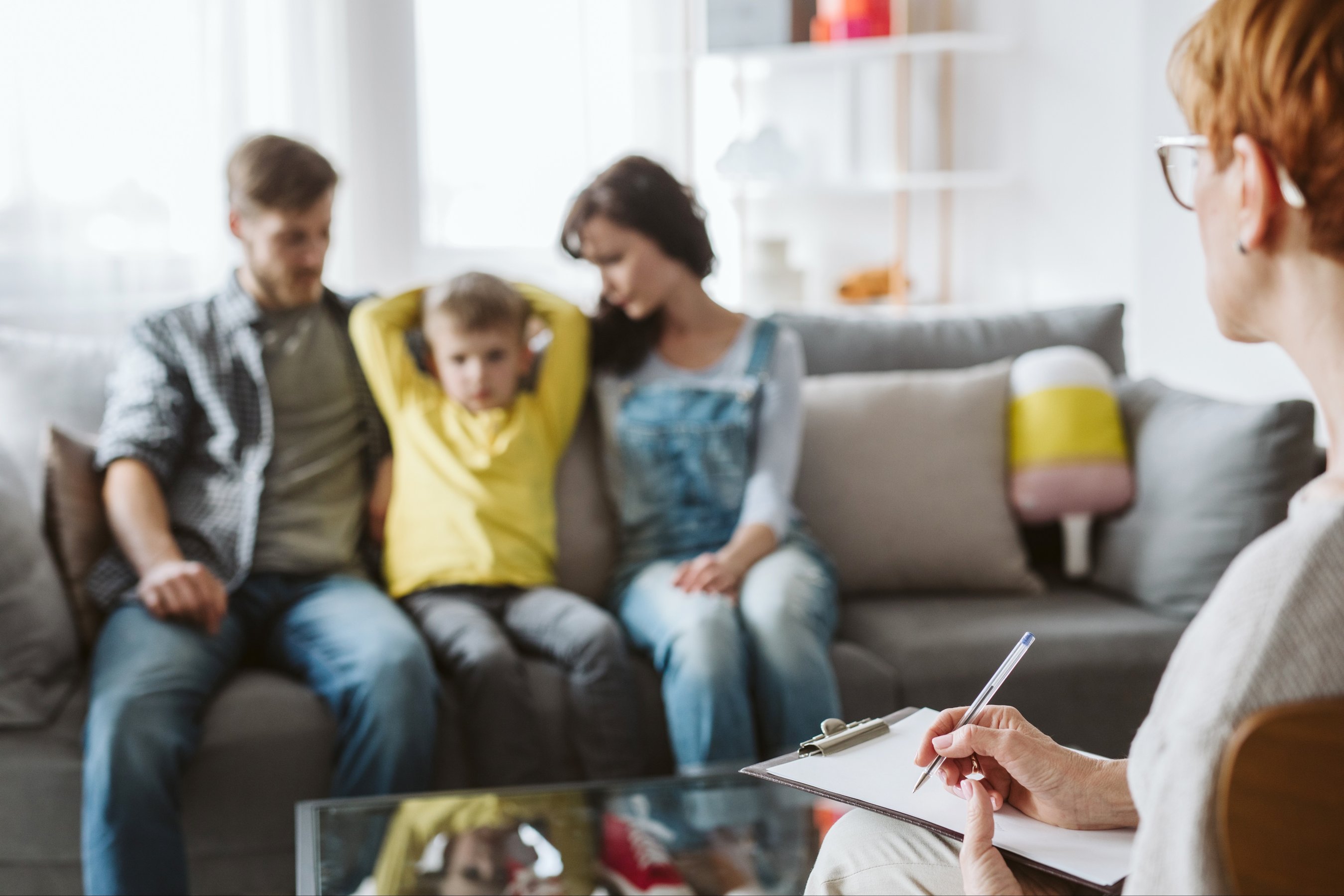 Woman and man with their son on a family psychotherapy with psychologist