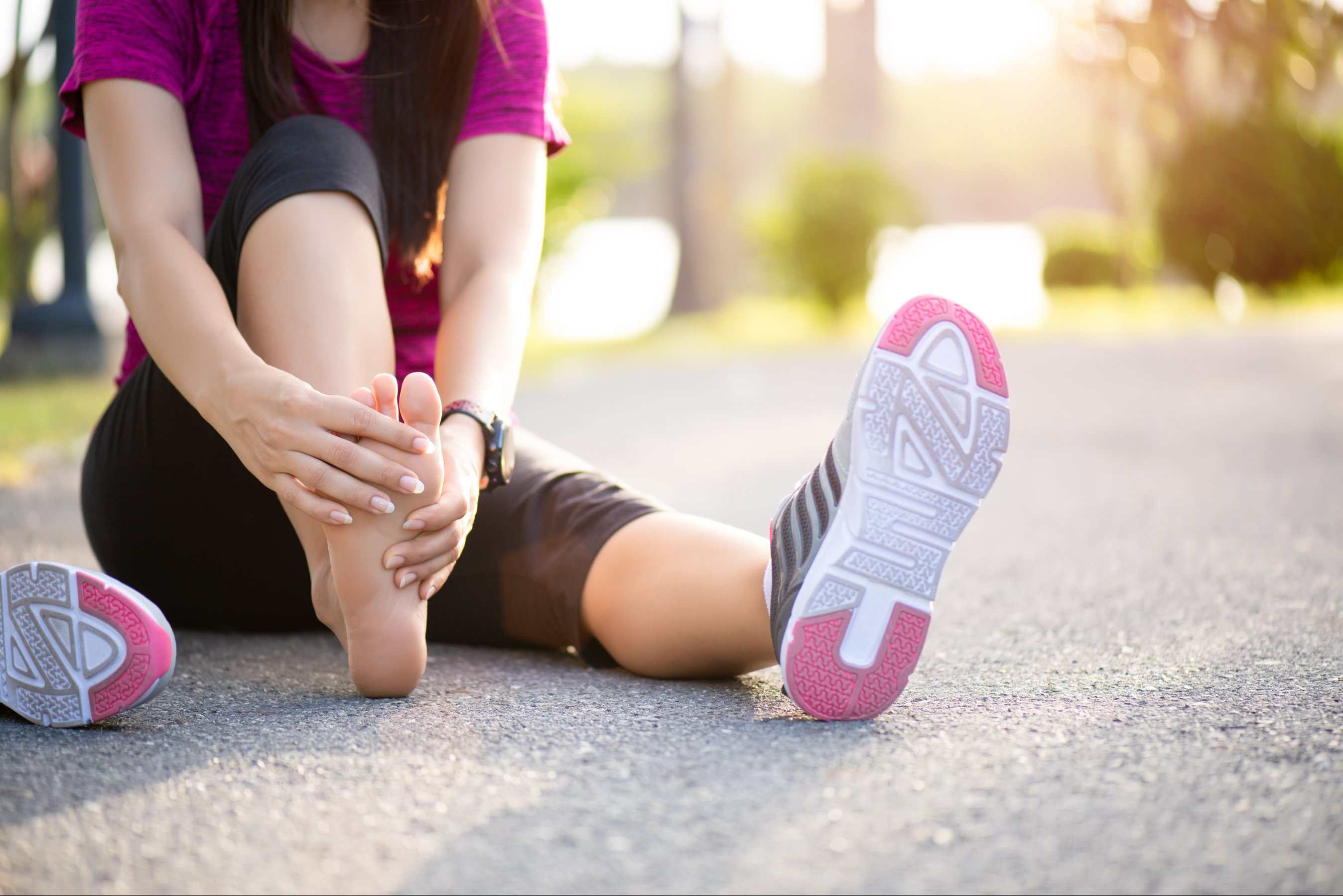 woman massaging her painful foot while exercising