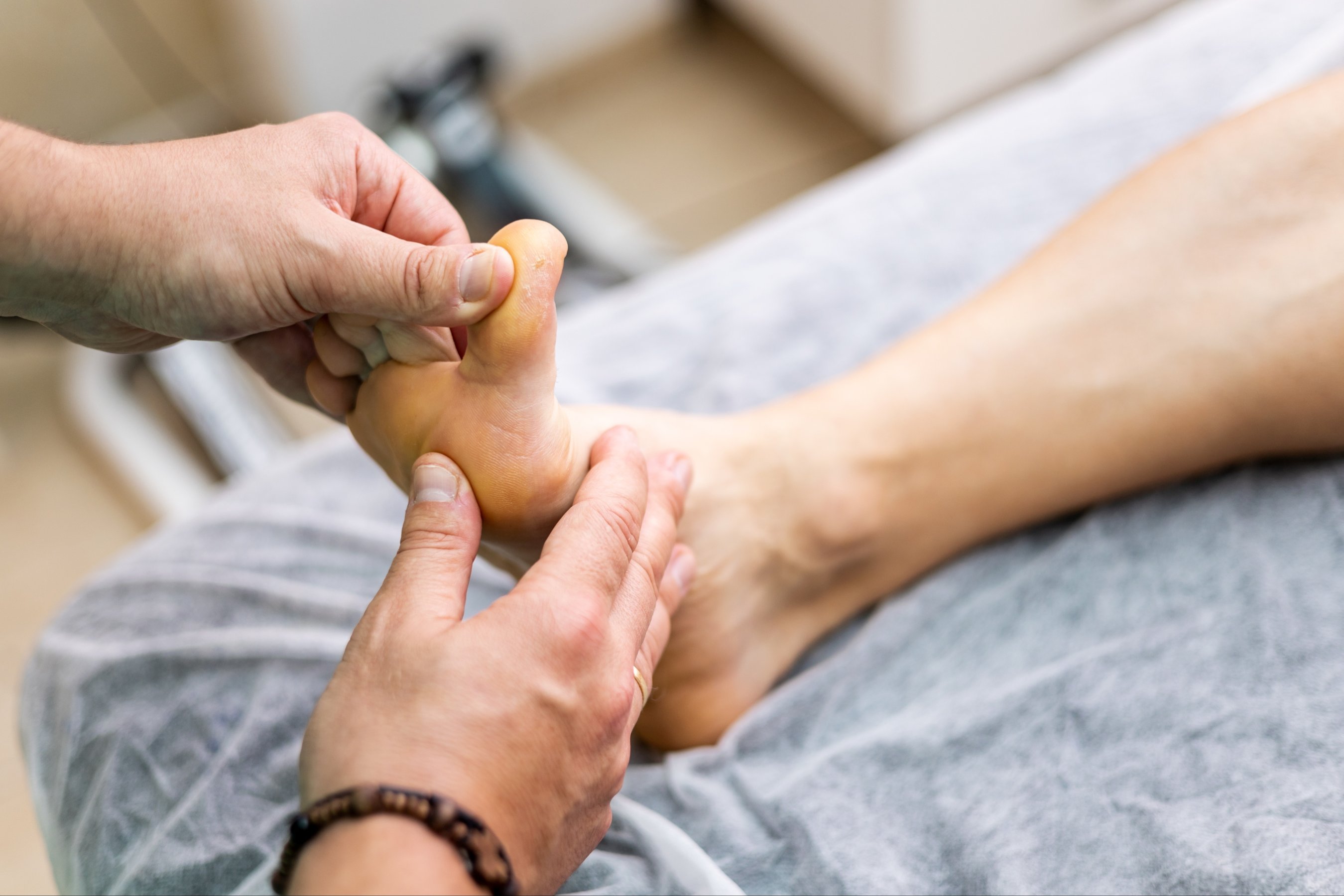 unrecognizable podiatrist is checking an athlete foot in a modern clinic