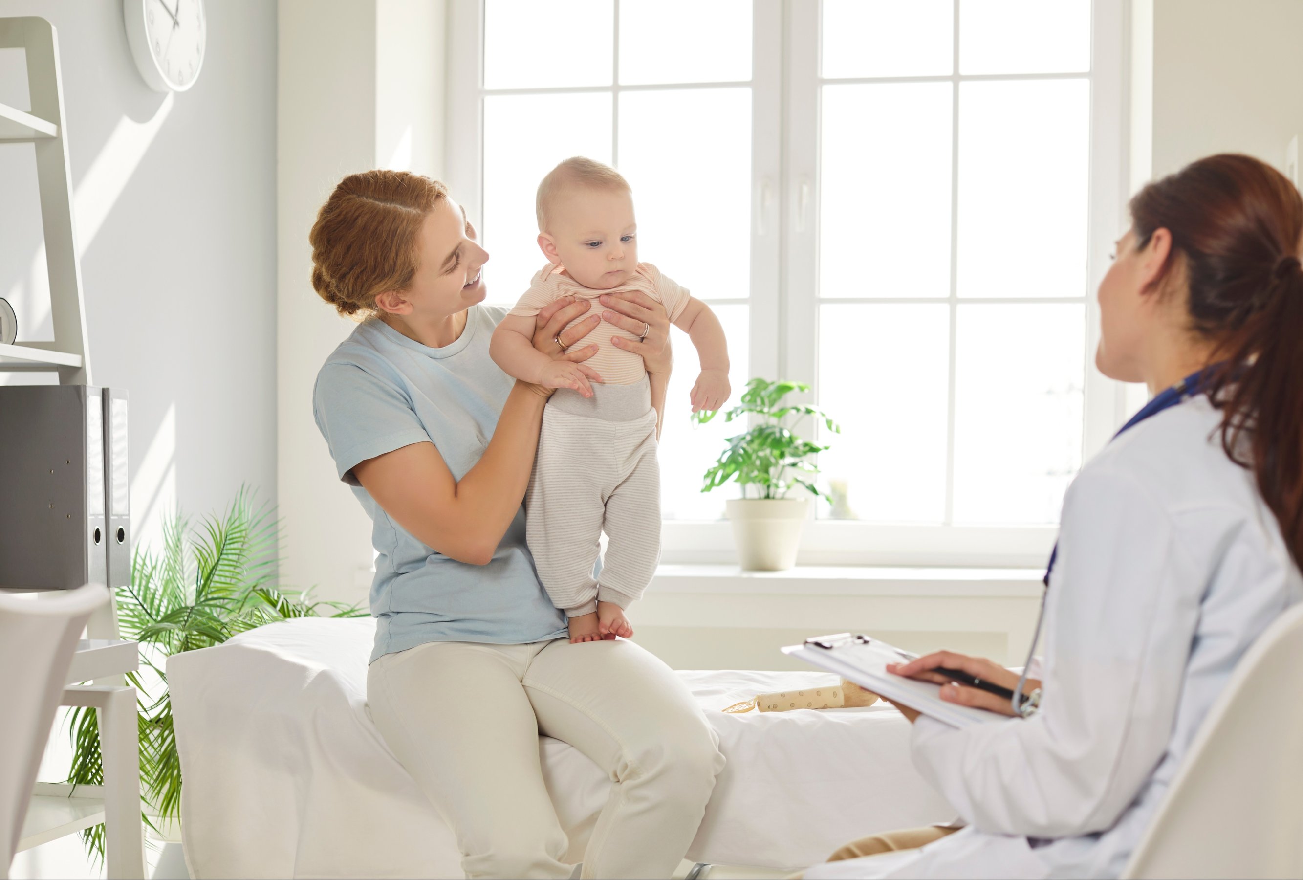 Mother and baby seeing doctor at pediatric clinic