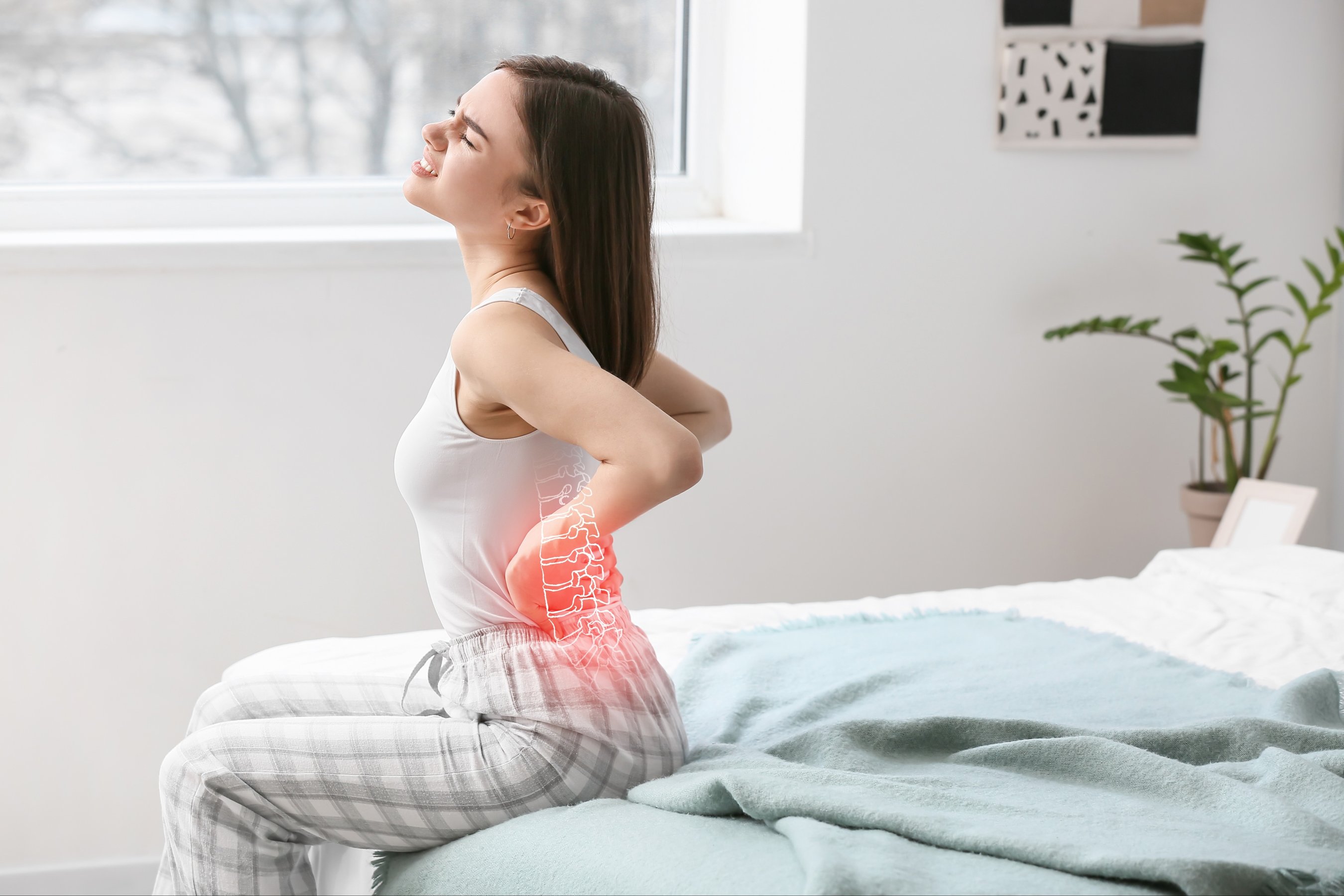 woman suffering from back pain in bedroom