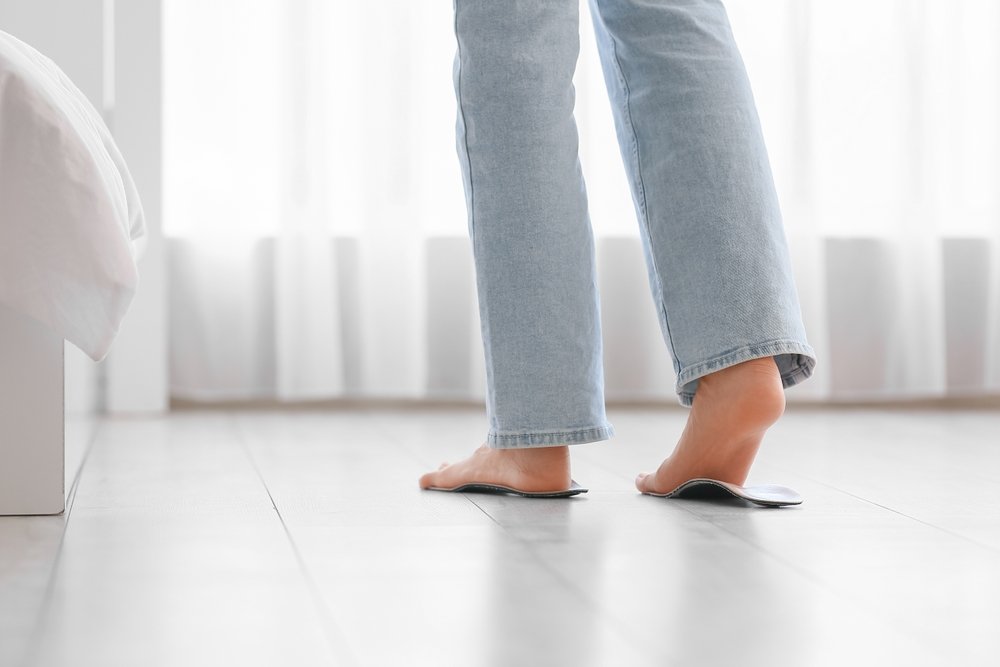 A nurse standing in a hospital hallway during a long shift on her feet