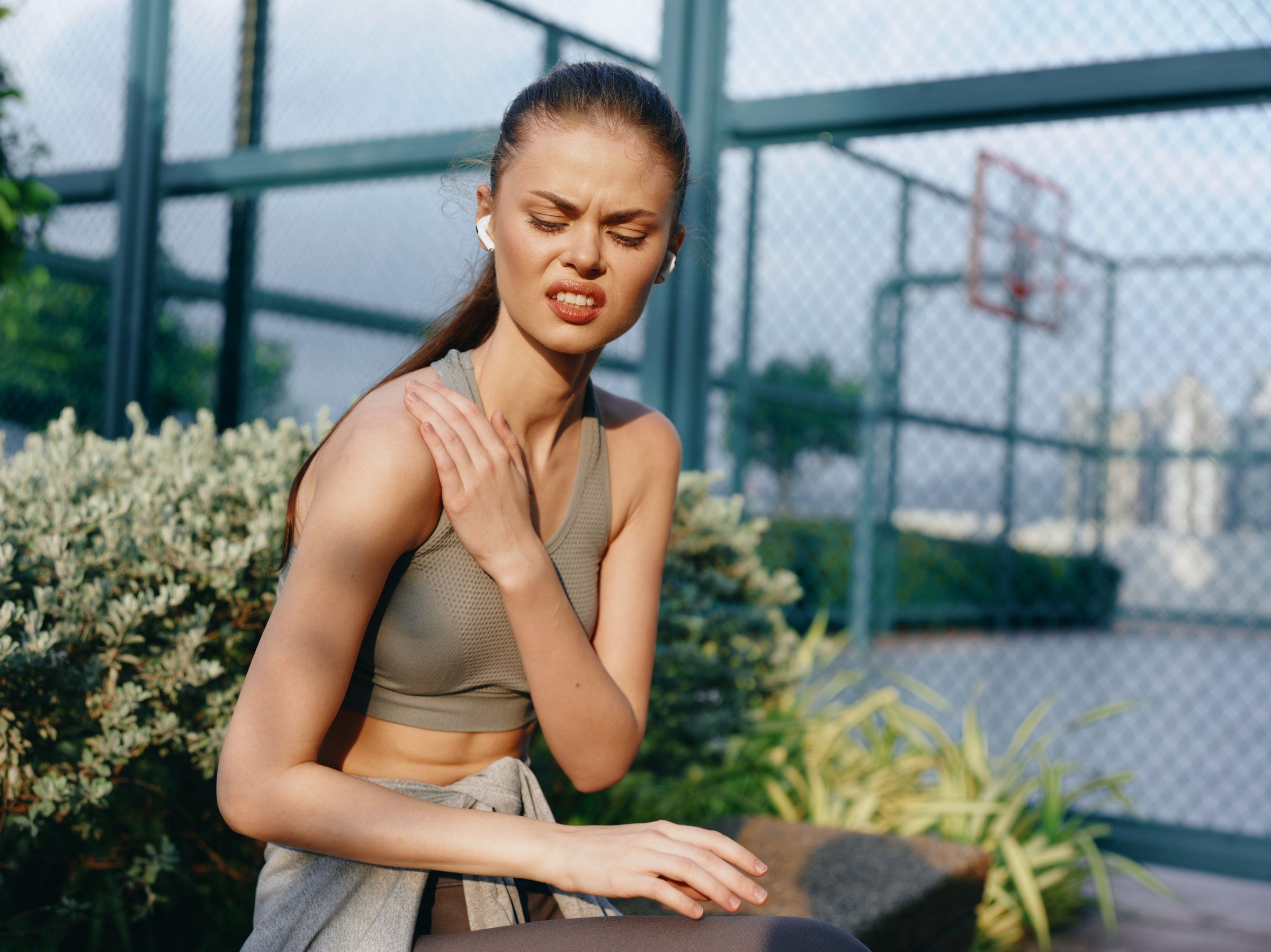 woman experiencing shoulder discomfort after workout