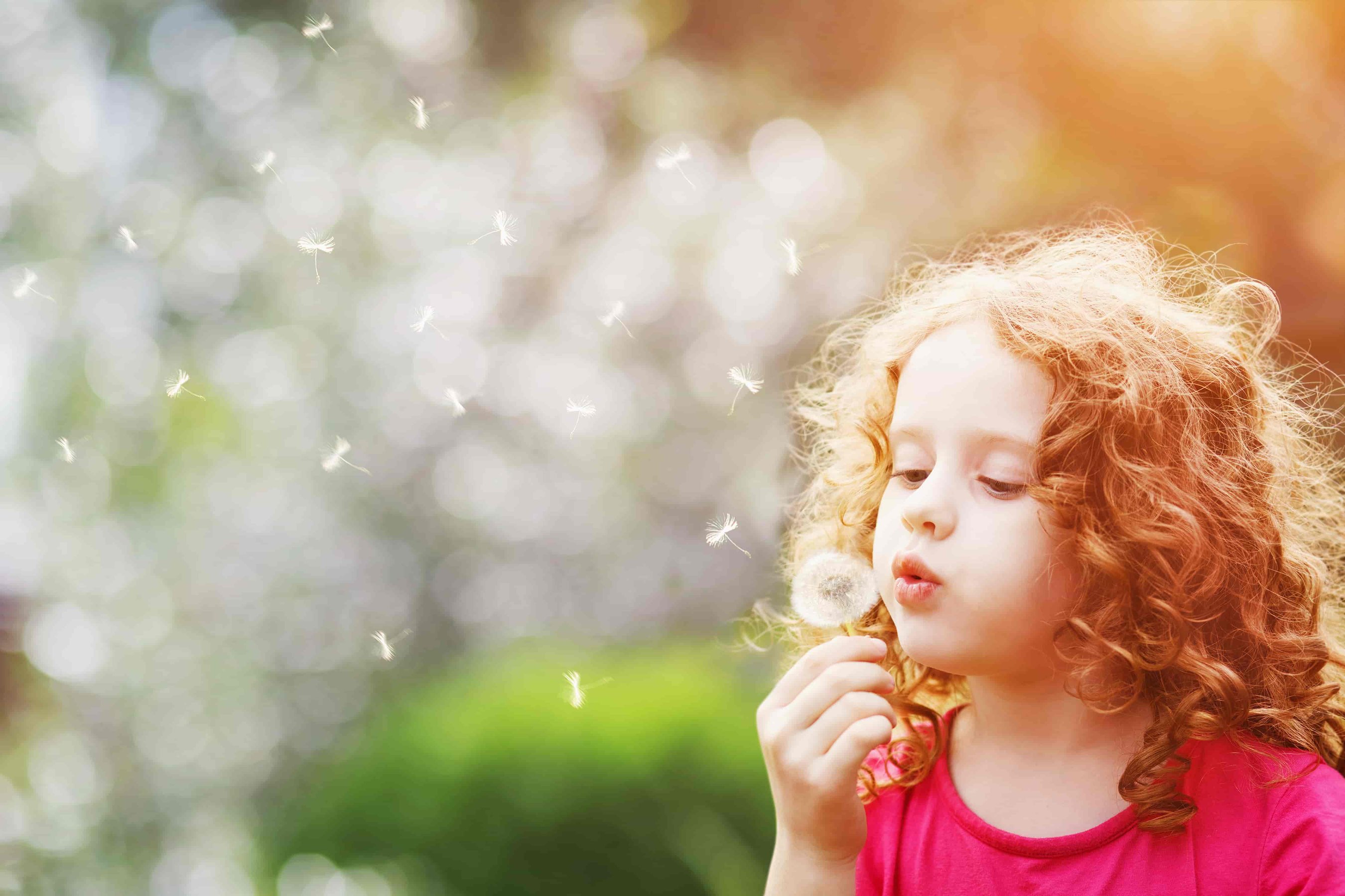 Girl blowing Dandelion