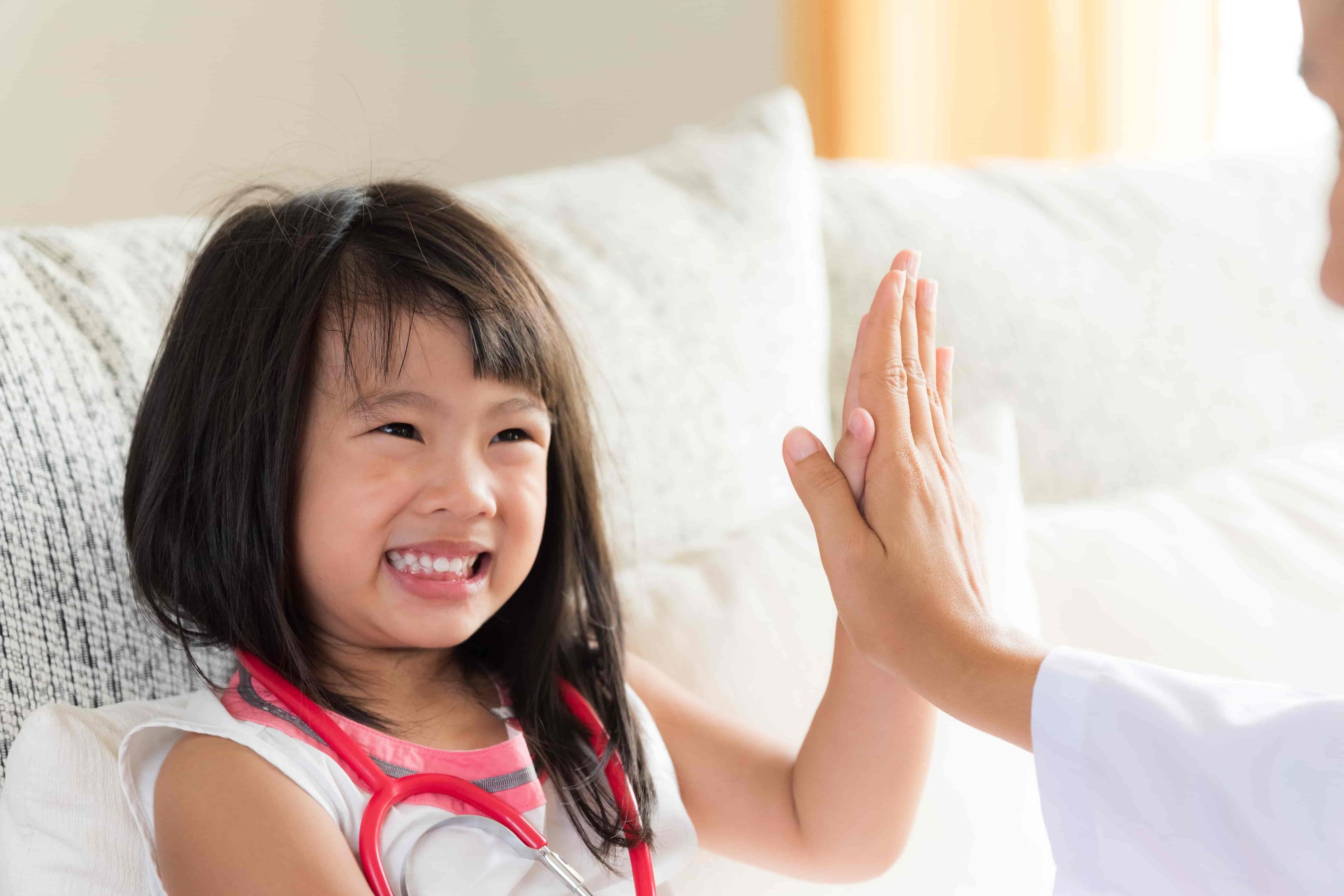 Smiling girl giving high five to Pediatrician