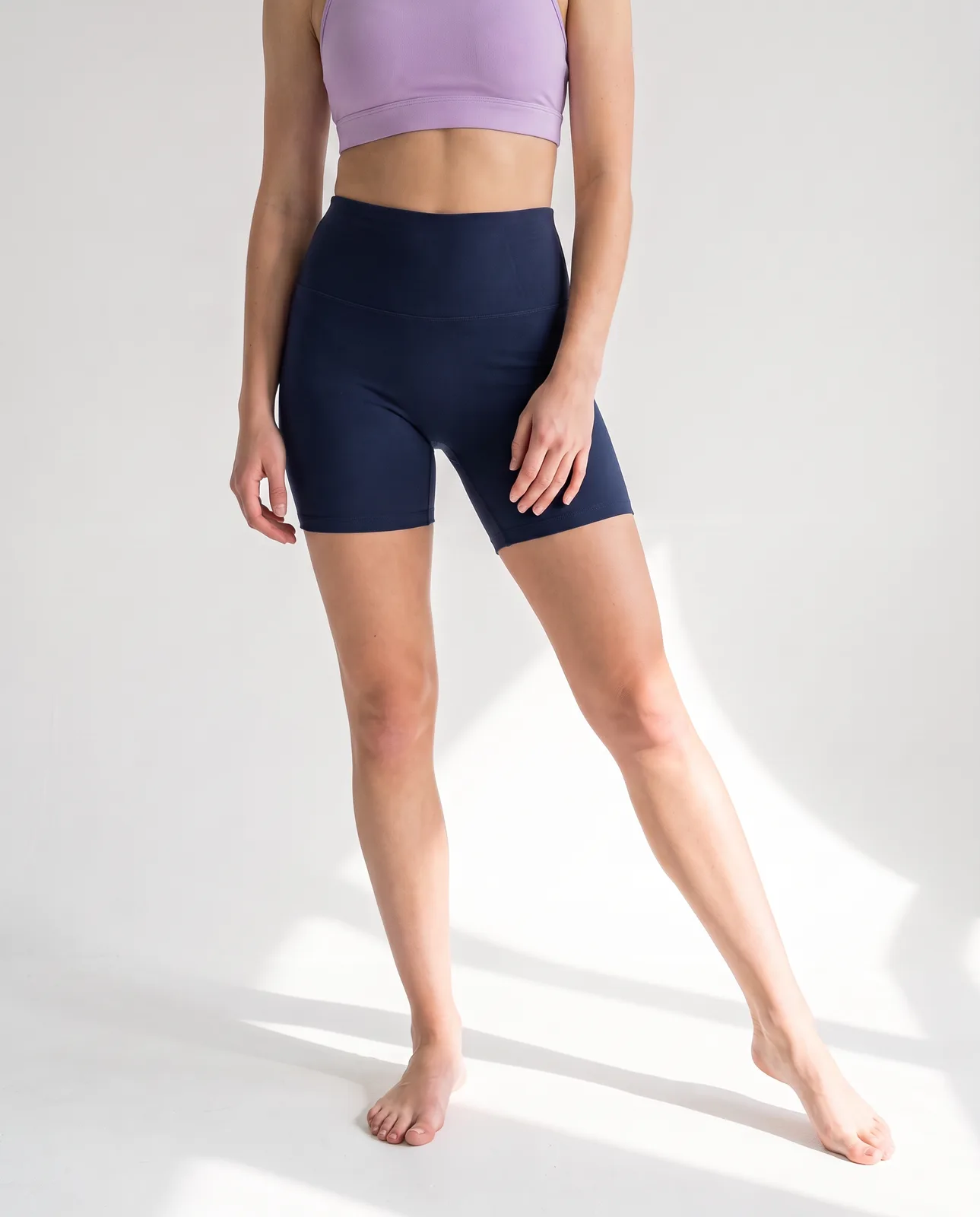 Detalle frontal de los shorts Foundation azul marino de talle alto con top lila
