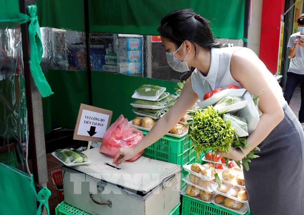 Người tiêu dùng tự bỏ tiền vào hộp khi mua sắm tại siêu thị không người bán.