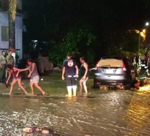 Gente cruzando por calles inundadas