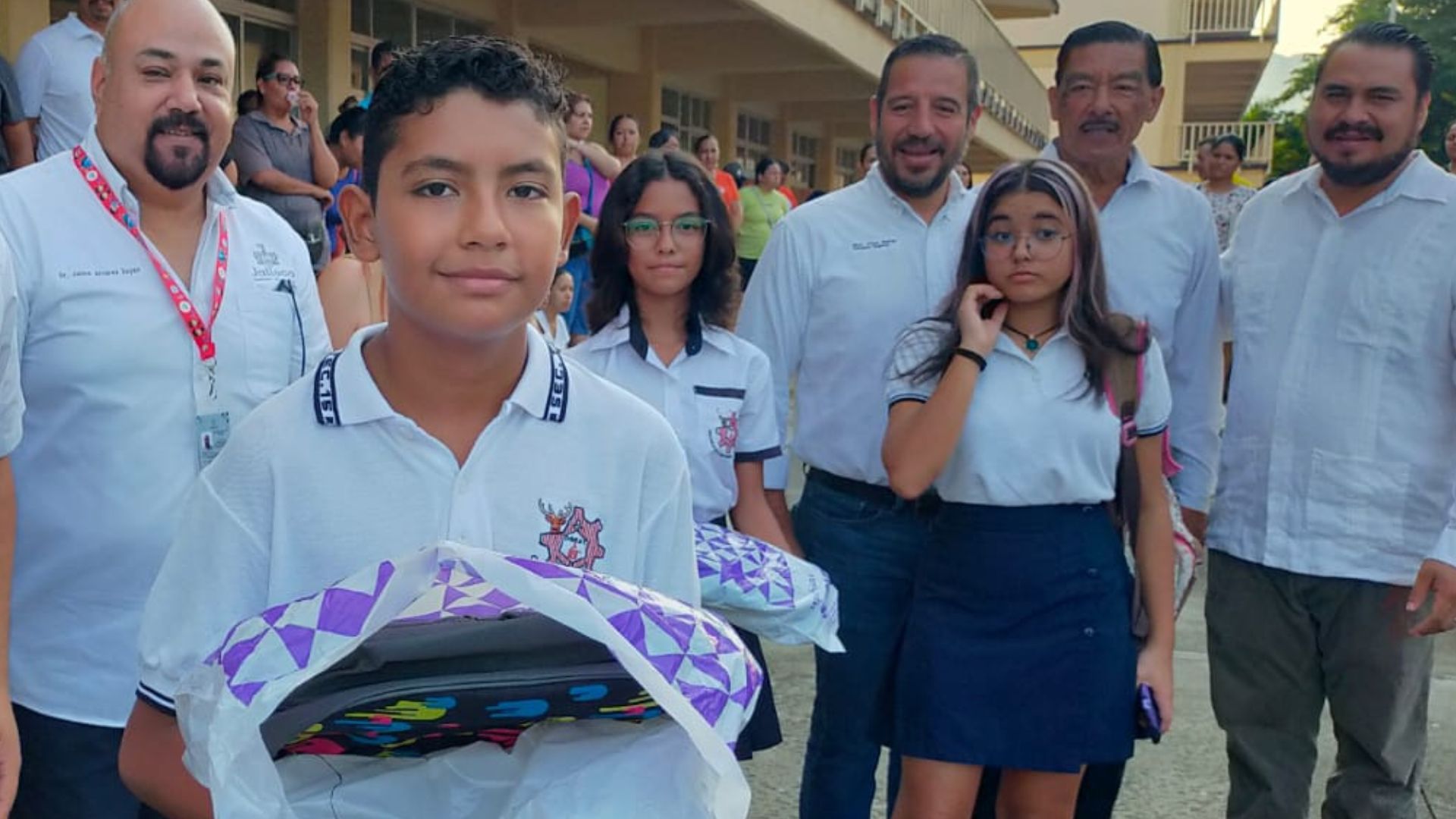 Alumno de Puerto Vallarta recibiendo útiles escolares.