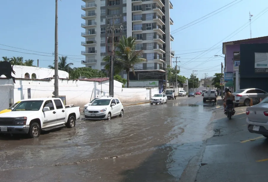 Autos circulando sobre aguas negras en el crucero de La Paloma.