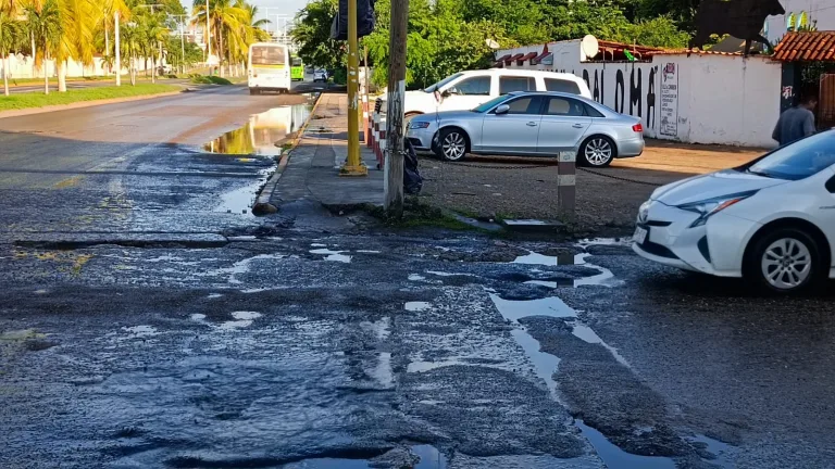 Calle remachada llena de bachecitos y agua