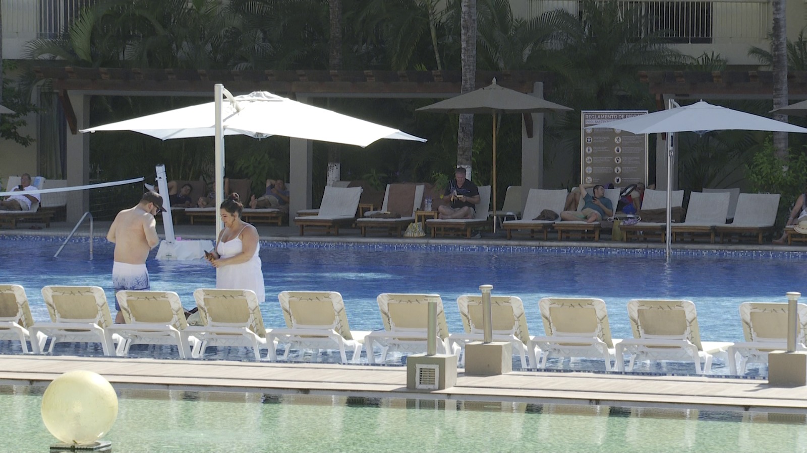 Turistas en piscina de hotel